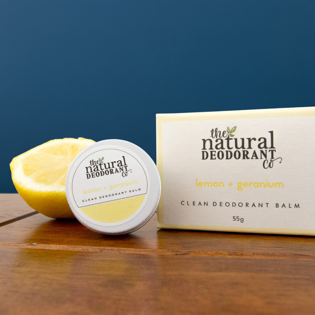 Deodorant balm and packaging with lemon on a wooden surface