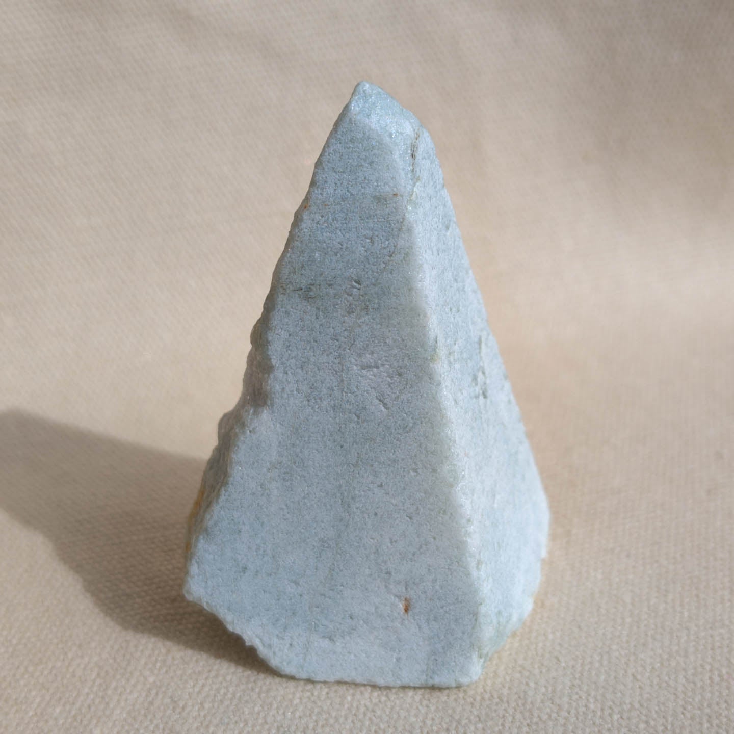 Medium raw amazonite crystal on fabric