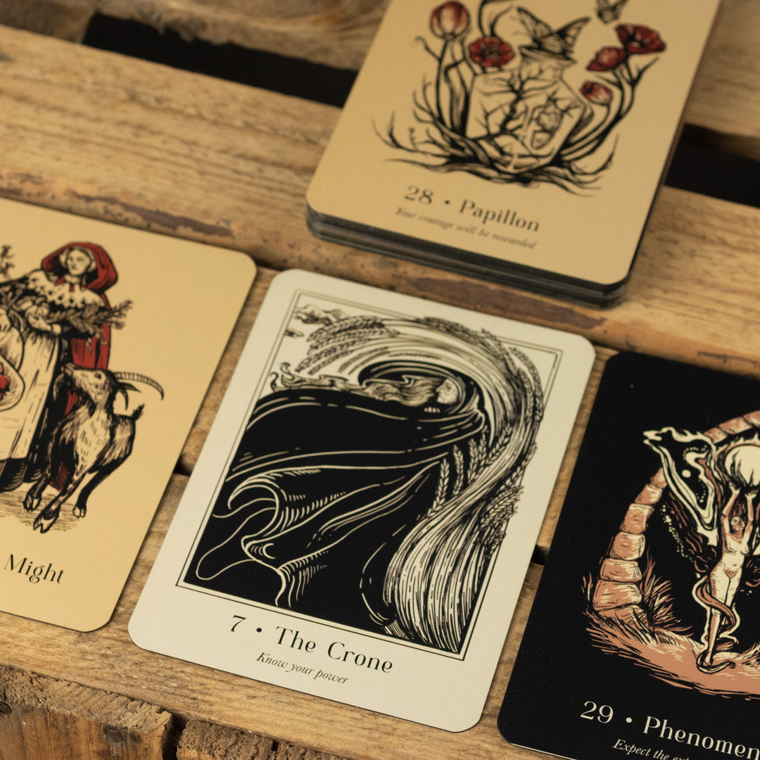 Collection of tarot cards from Lost Oracle Card Deck with intricate designs on a wooden surface