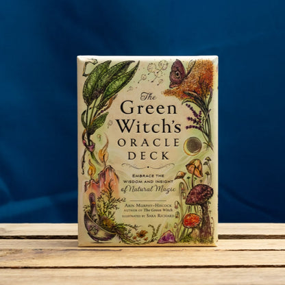 The Green Witch's Oracle Deck on a wooden surface with a blue background