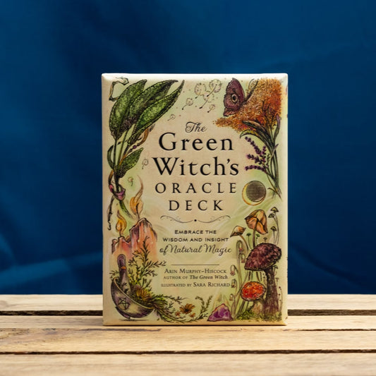 The Green Witch's Oracle Deck on a wooden surface with a blue background
