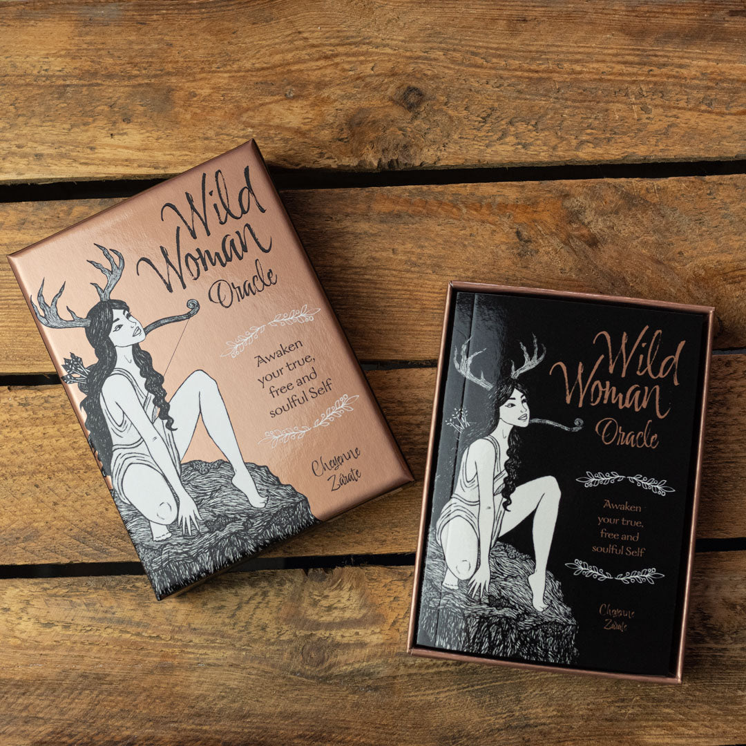 'Wild Woman Oracle' card boxes on a wooden surface