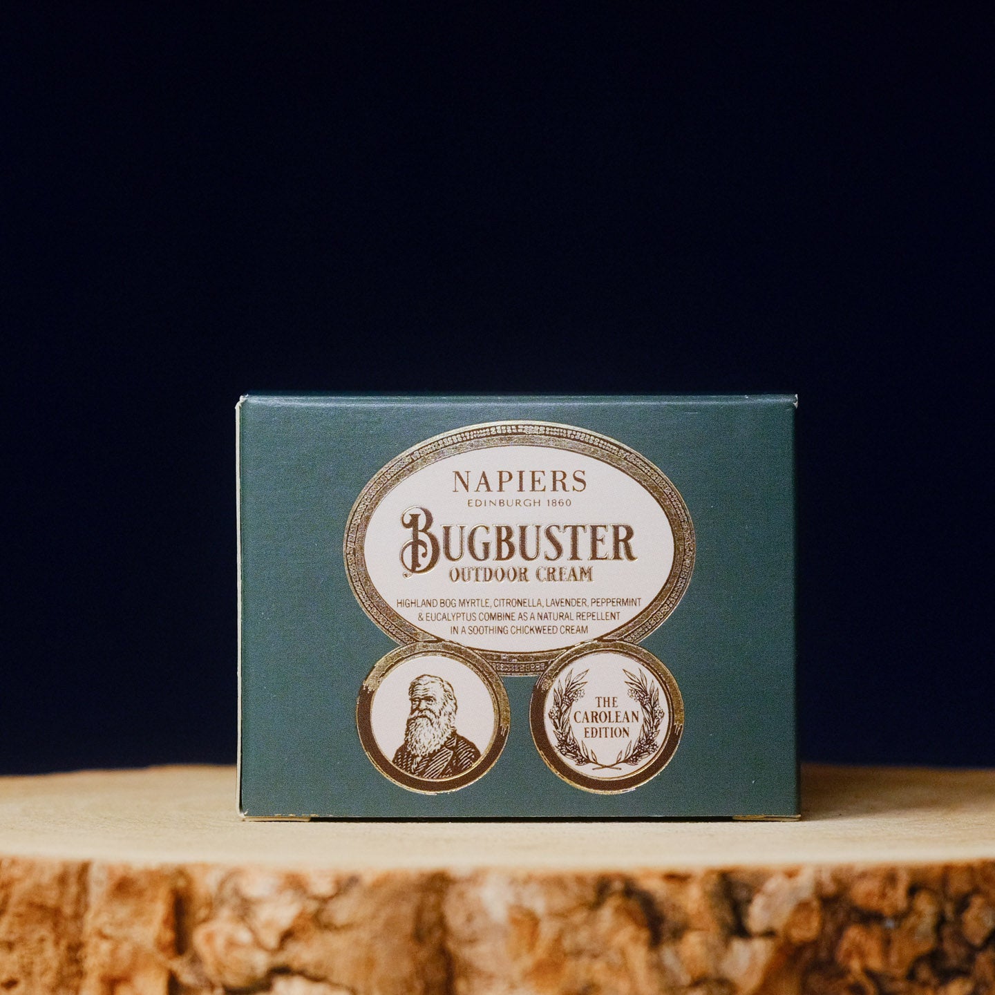 Napiers Bugbuster outdoor cream packaging on a wooden surface with a dark background