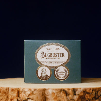 Napiers Bugbuster outdoor cream packaging on a wooden surface with a dark background