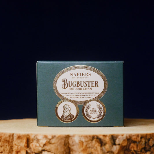 Napiers Bugbuster outdoor cream packaging on a wooden surface with a dark background