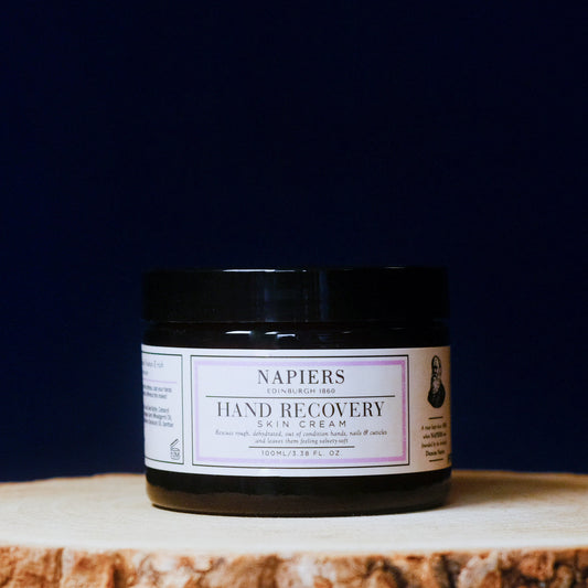 Napiers Hand Recovery Skin Cream jar on a wooden surface with a dark background