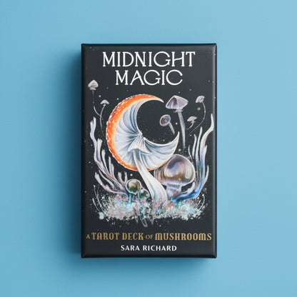 Tarot deck packaging titled 'Midnight Magic' with mushroom illustrations on a blue fabric background