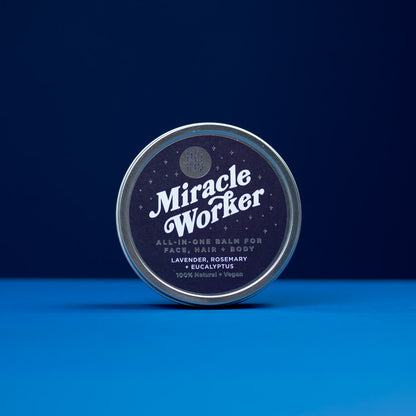 Tin of 'Miracle Worker' all-in-one balm on a blue background