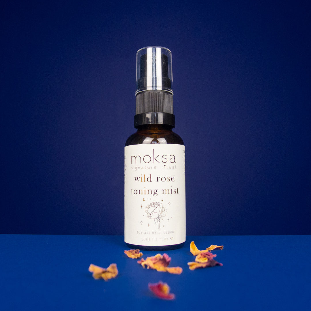 Moksa wild rose toning mist bottle with dried flowers on a blue background