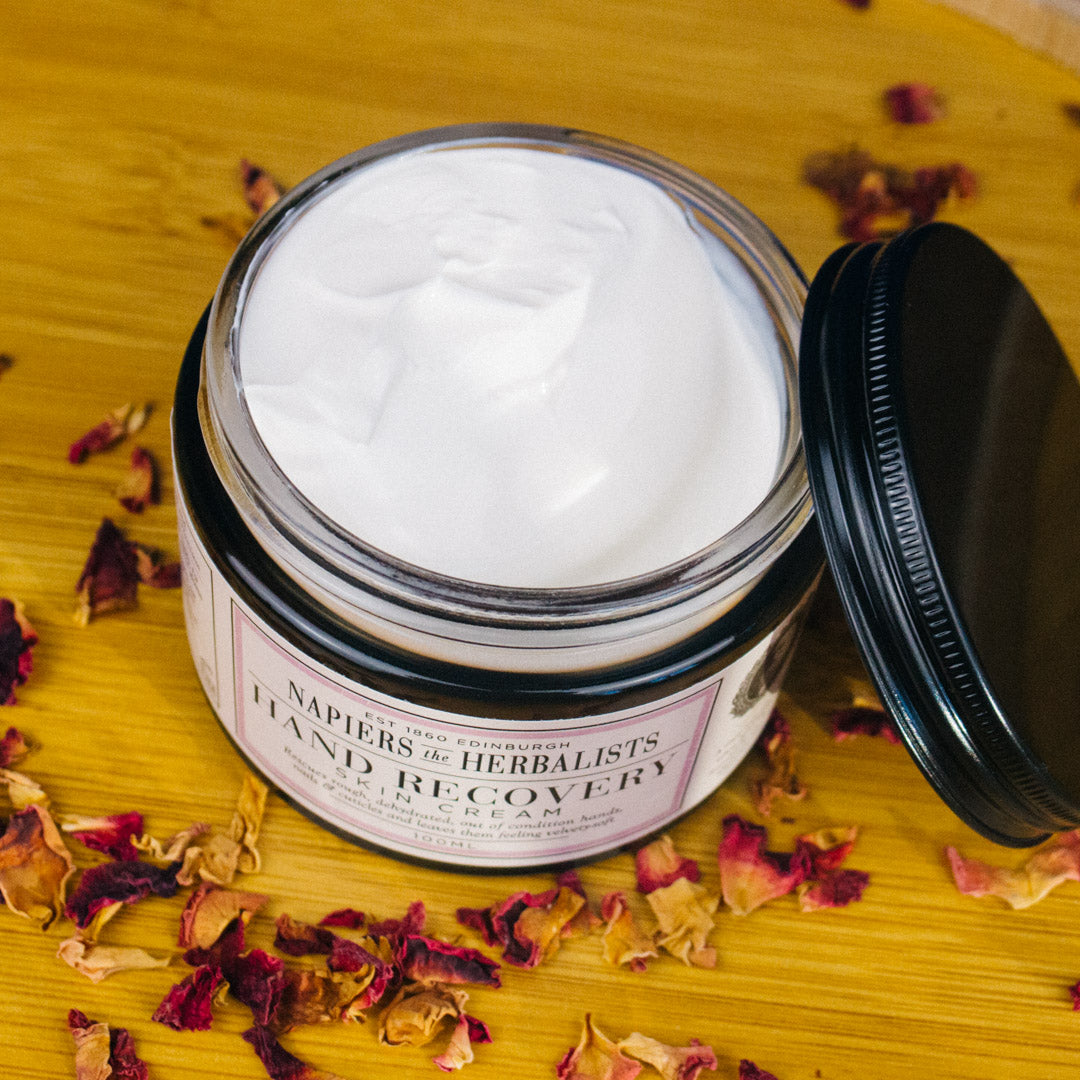 Napiers hand recovery cream on wooden background with rose petals