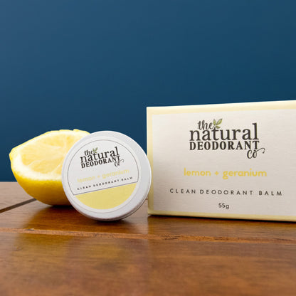 Deodorant balm and packaging with lemon on a wooden surface