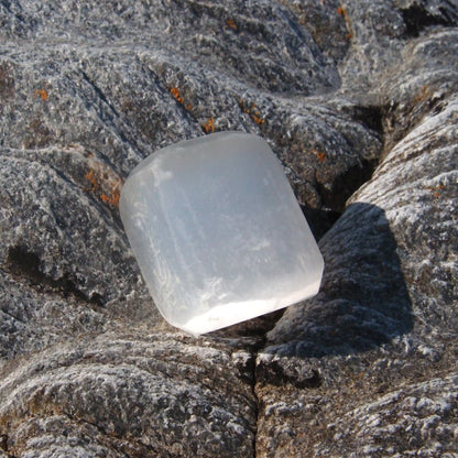 Clear selenite crystal stone on a rocky surface