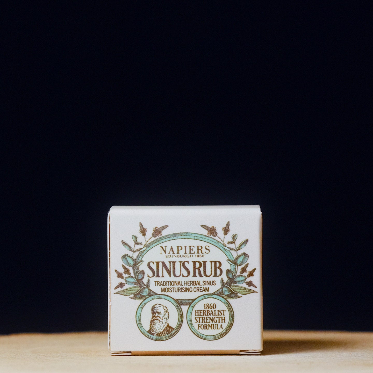 Napier's Sinus Rub cream packaging on a wooden surface with a black background