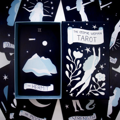 Tarot card set with 'The Hermit' card and 'The Cosmic Woman Tarot' packaging.