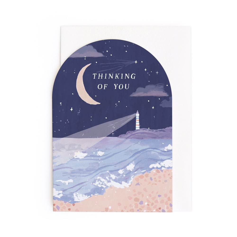 Greeting card with a lighthouse, moon, and stars on a night sky background.
