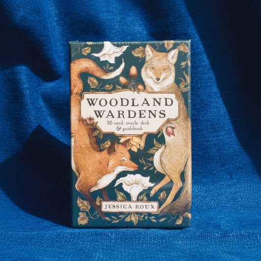 Woodland Wardens oracle deck packaging with fox and deer illustrations on a blue fabric background
