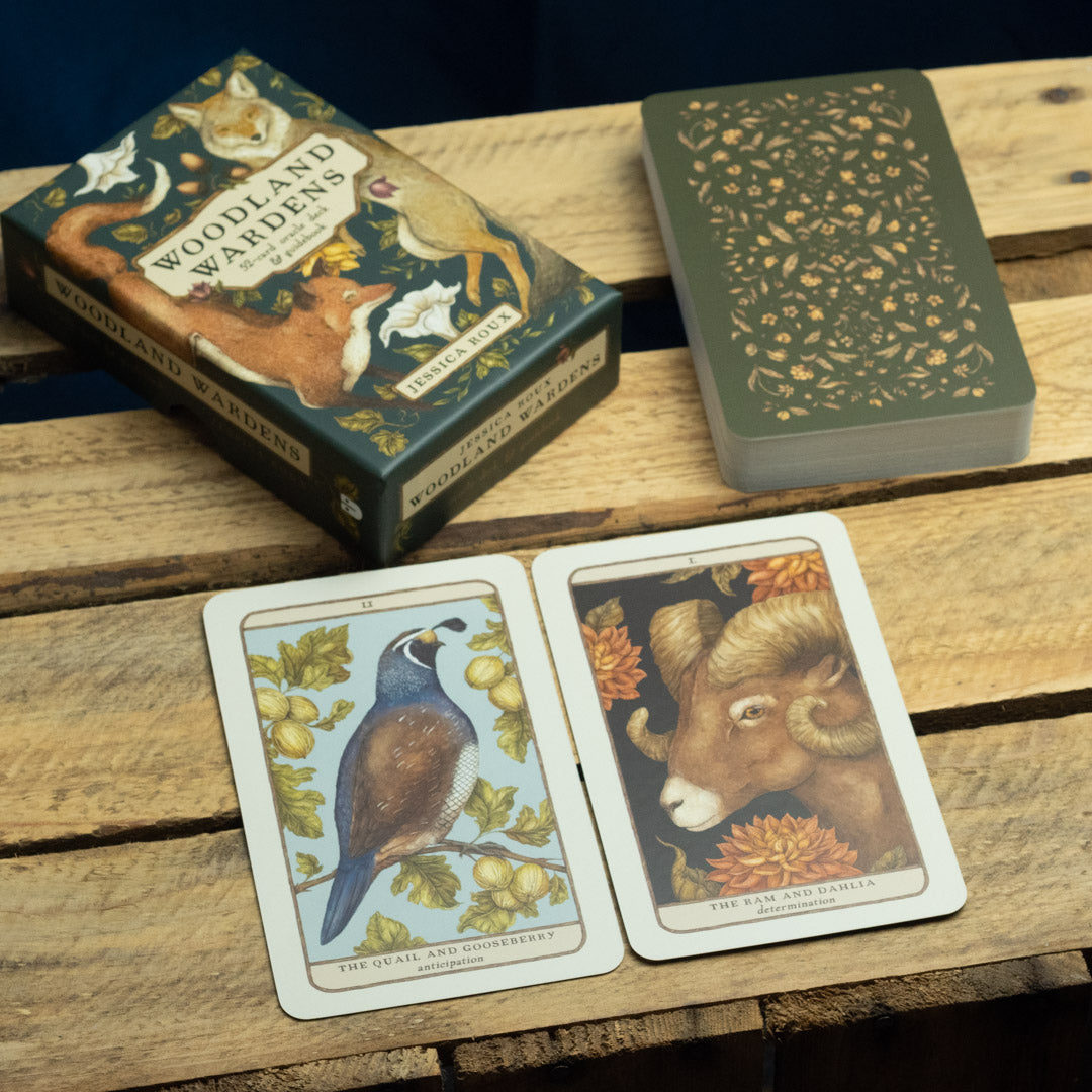 Woodland Wardens oracle cards on a wooden surface with one card open showing an animal illustration.