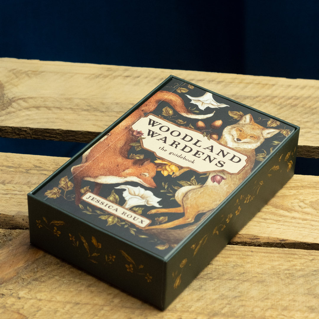 Woodland Warden's Oracle Deck guidebook in box with fox illustrations on a wooden surface